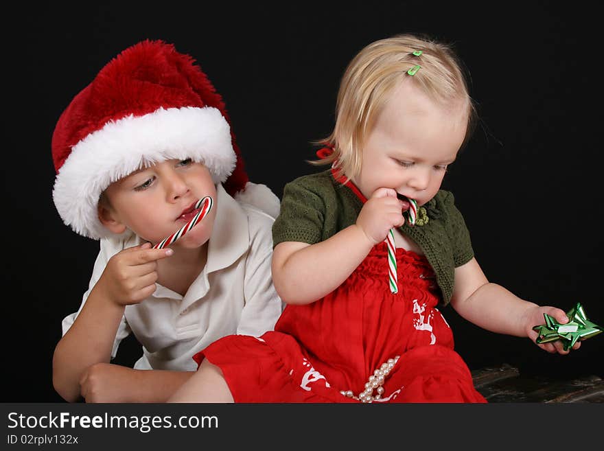 Christmas brother and sister eating Candy Canes. Christmas brother and sister eating Candy Canes