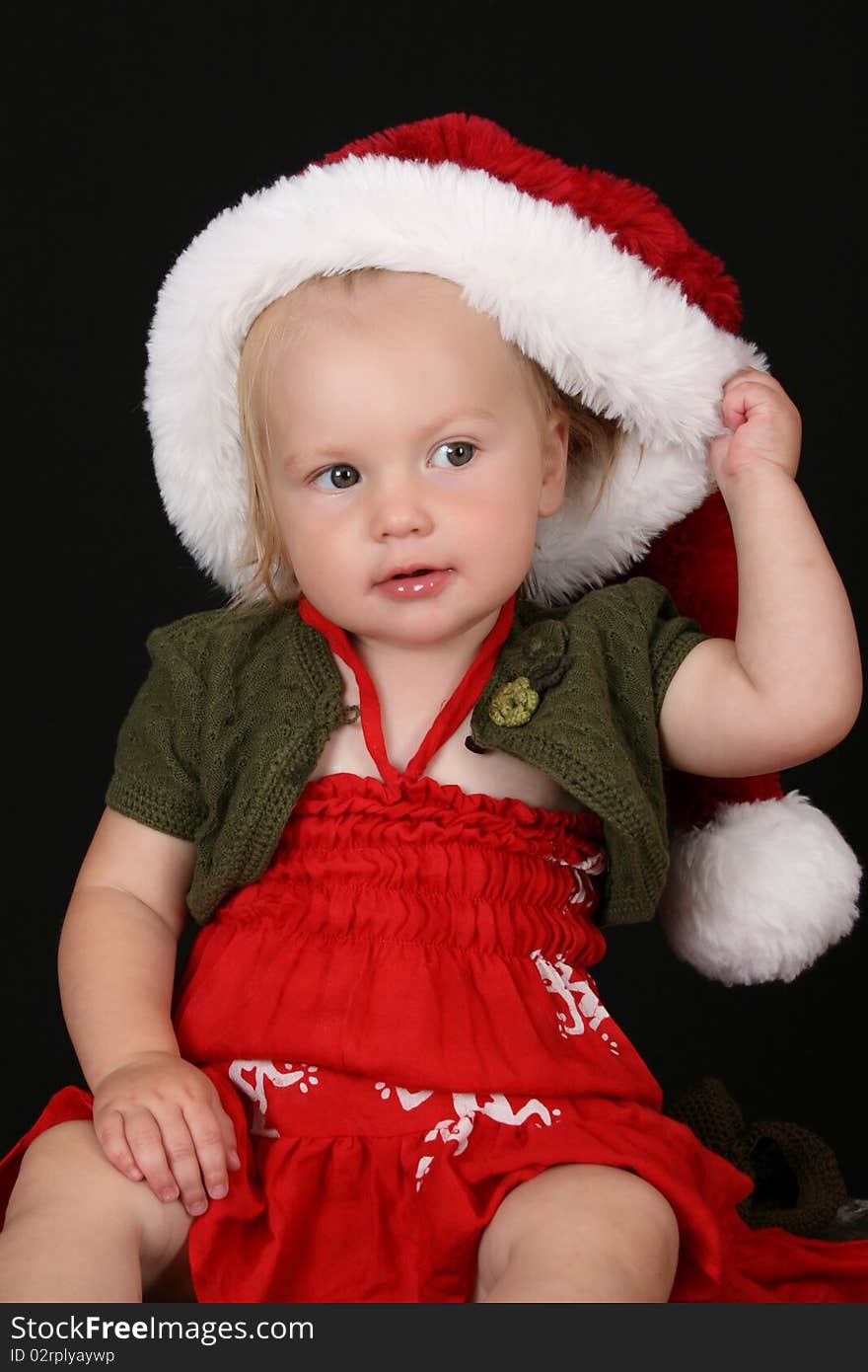 Cute blond girl wearing a red dress and christmas hat. Cute blond girl wearing a red dress and christmas hat