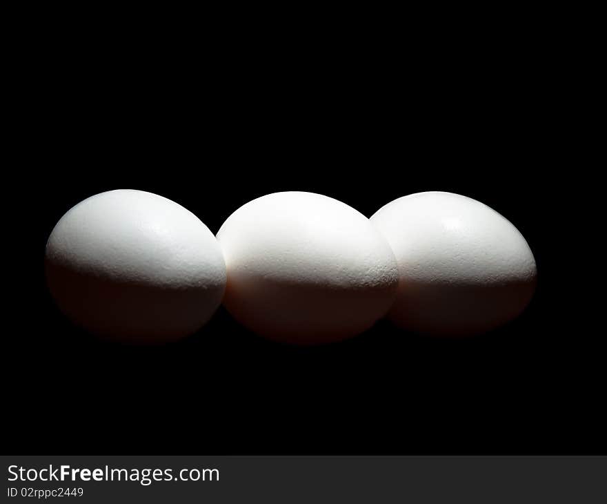 Egg trio on pure black background