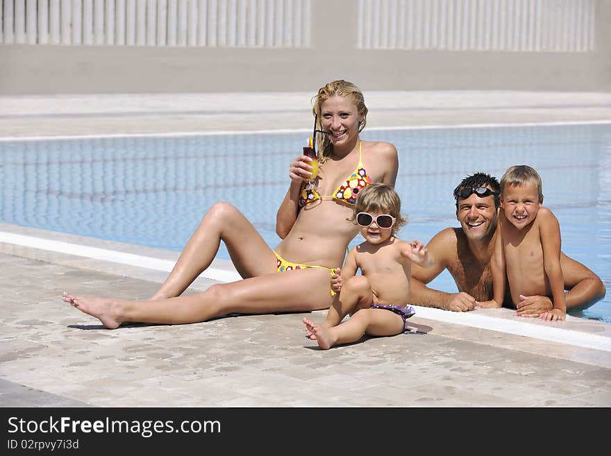 Happy young family have fun on swimming pool at summer vacation