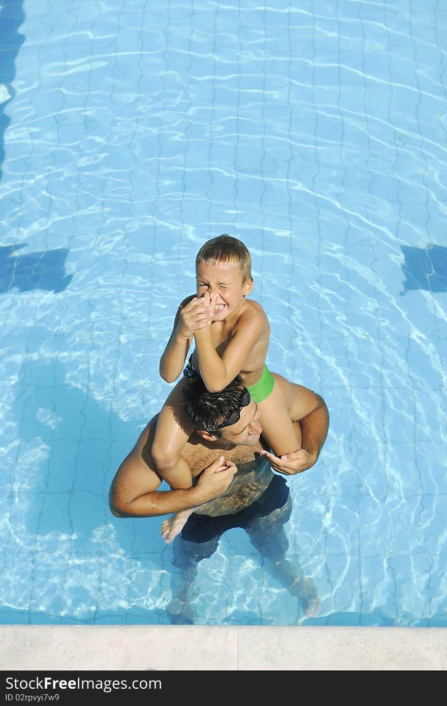 Happy father and son at swimming pool