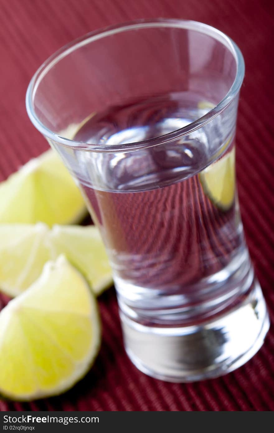 Shot glass filled with clear cold alcohol. Shot glass filled with clear cold alcohol