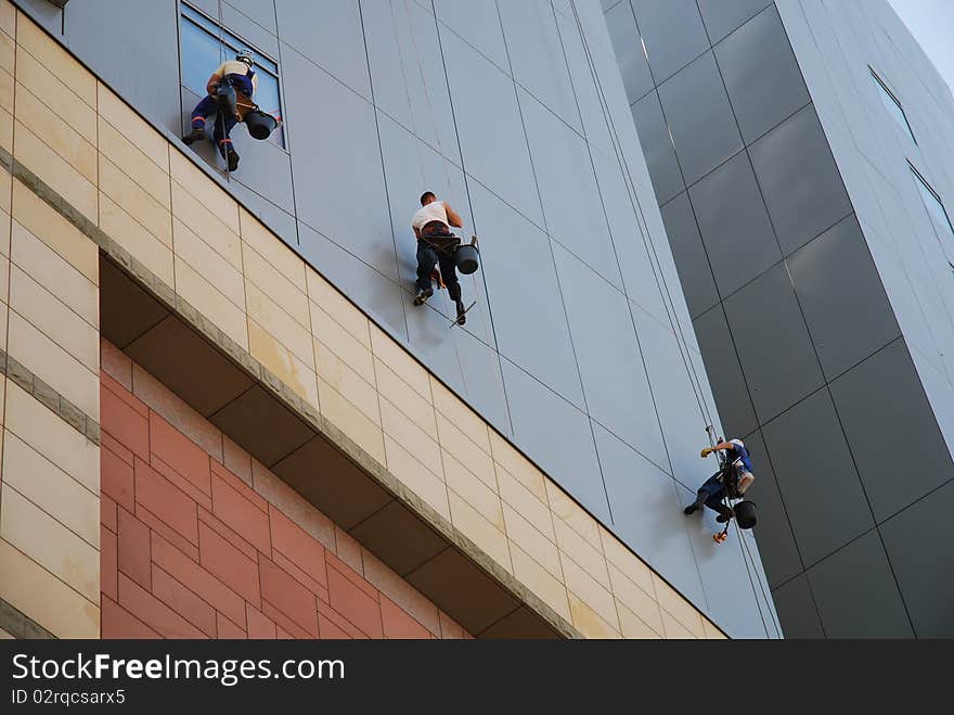 Image of people climbing up the wall of building. Image of people climbing up the wall of building