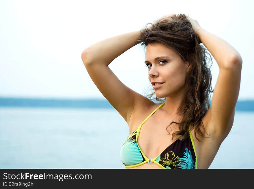 Beautiful woman in bikini relaxing on the river shore