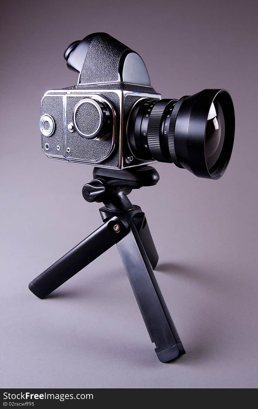 Camera on tripod on gray background