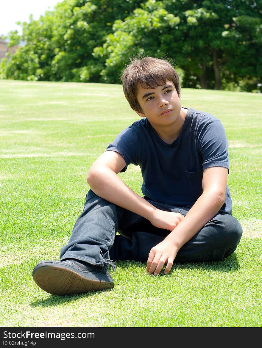 Young Boy Sitting on Grass