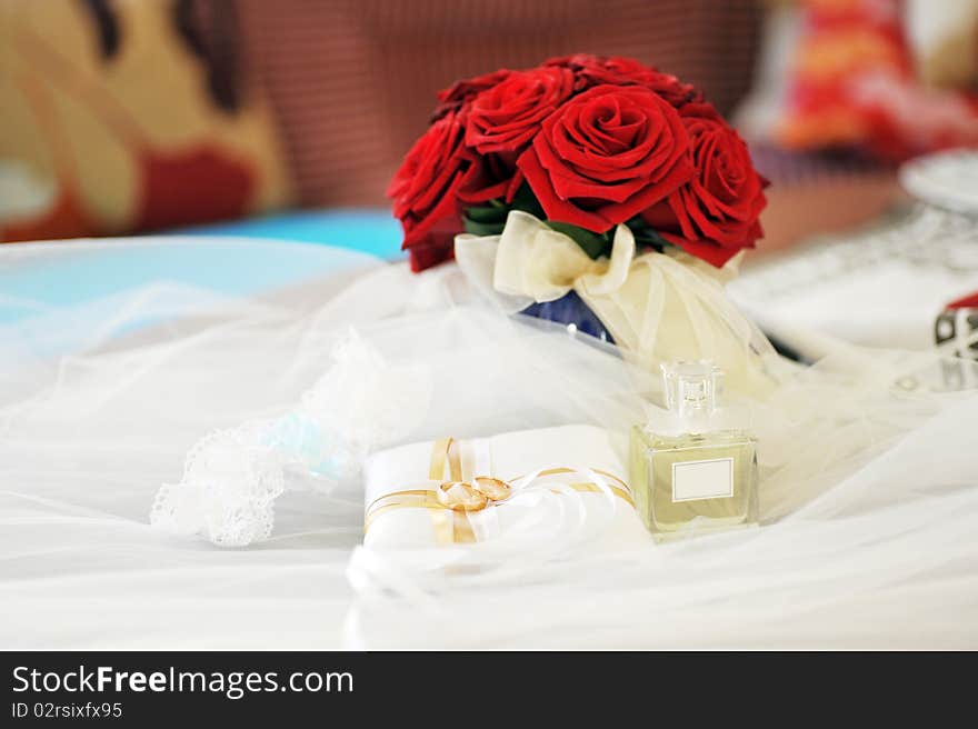 Garter, roses, perfume and wedding rings. Garter, roses, perfume and wedding rings