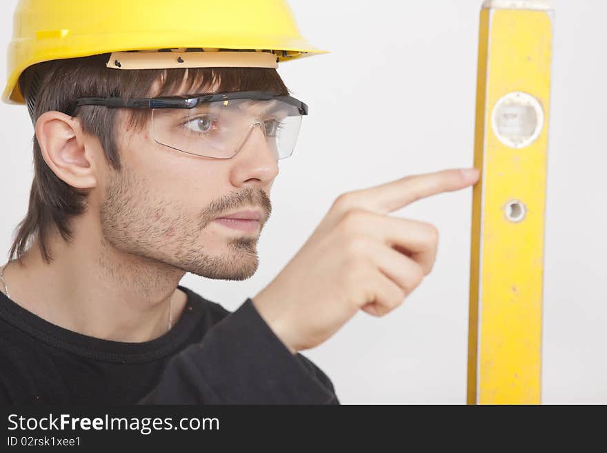 Portrait of construction worker with level on white background