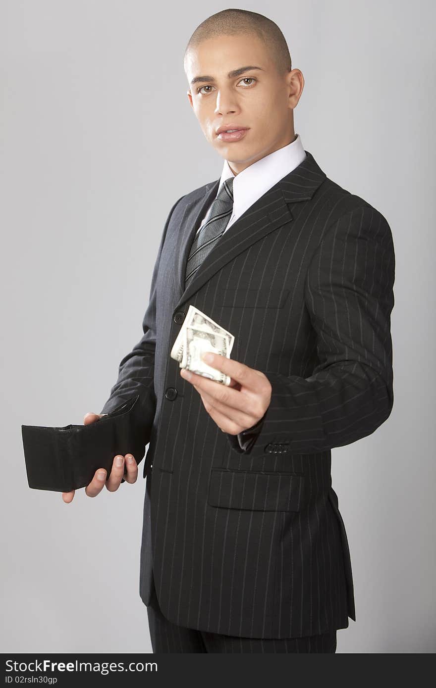 A young good looking businessman on a gray background. A young good looking businessman on a gray background.