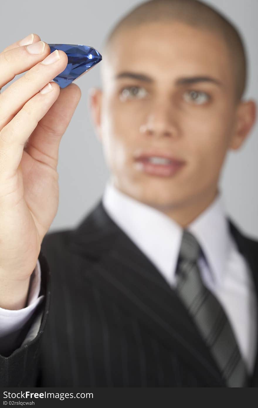 A young good looking businessman on a gray background. A young good looking businessman on a gray background.