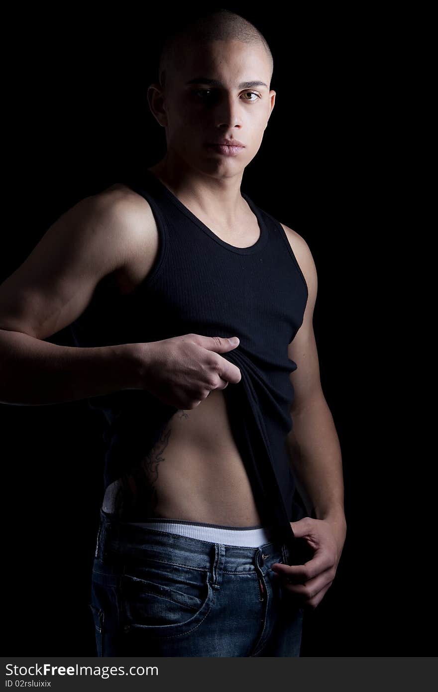 A good looking, muscular built, man on a black background. A good looking, muscular built, man on a black background.