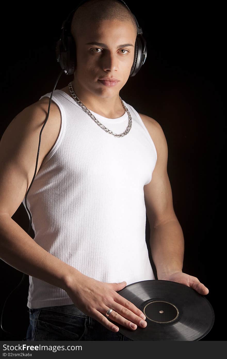 A good looking, muscular built, man on a black background with earphones. A good looking, muscular built, man on a black background with earphones.