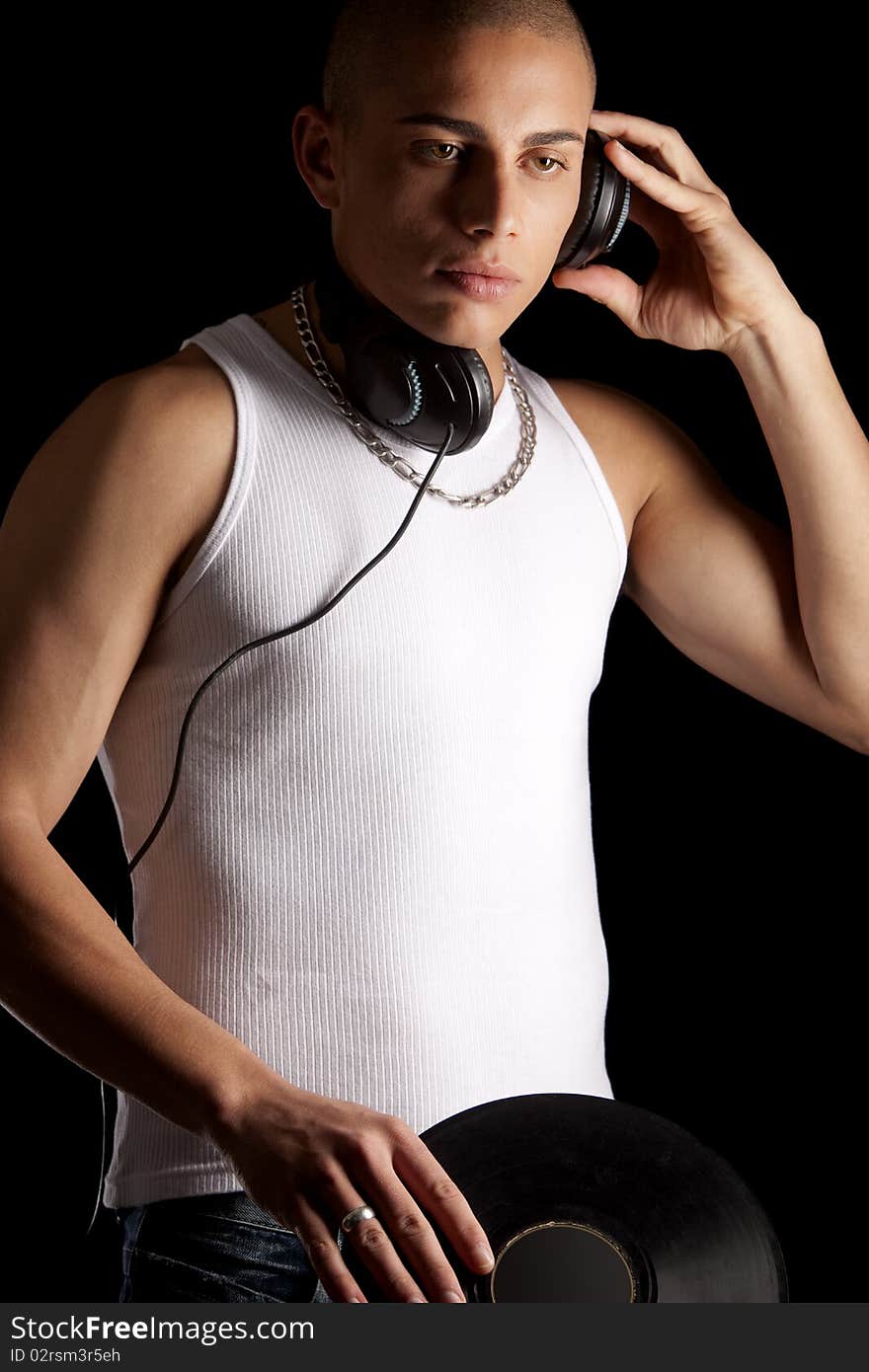 A good looking, muscular built, man on a black background with earphones. A good looking, muscular built, man on a black background with earphones.