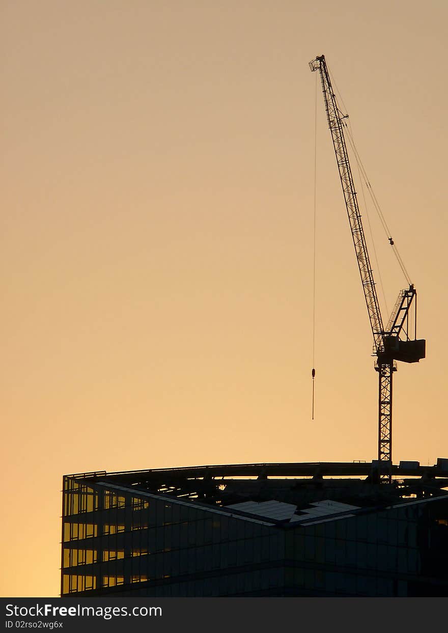 Under construction building against the coming sun. A city. Under construction building against the coming sun. A city.