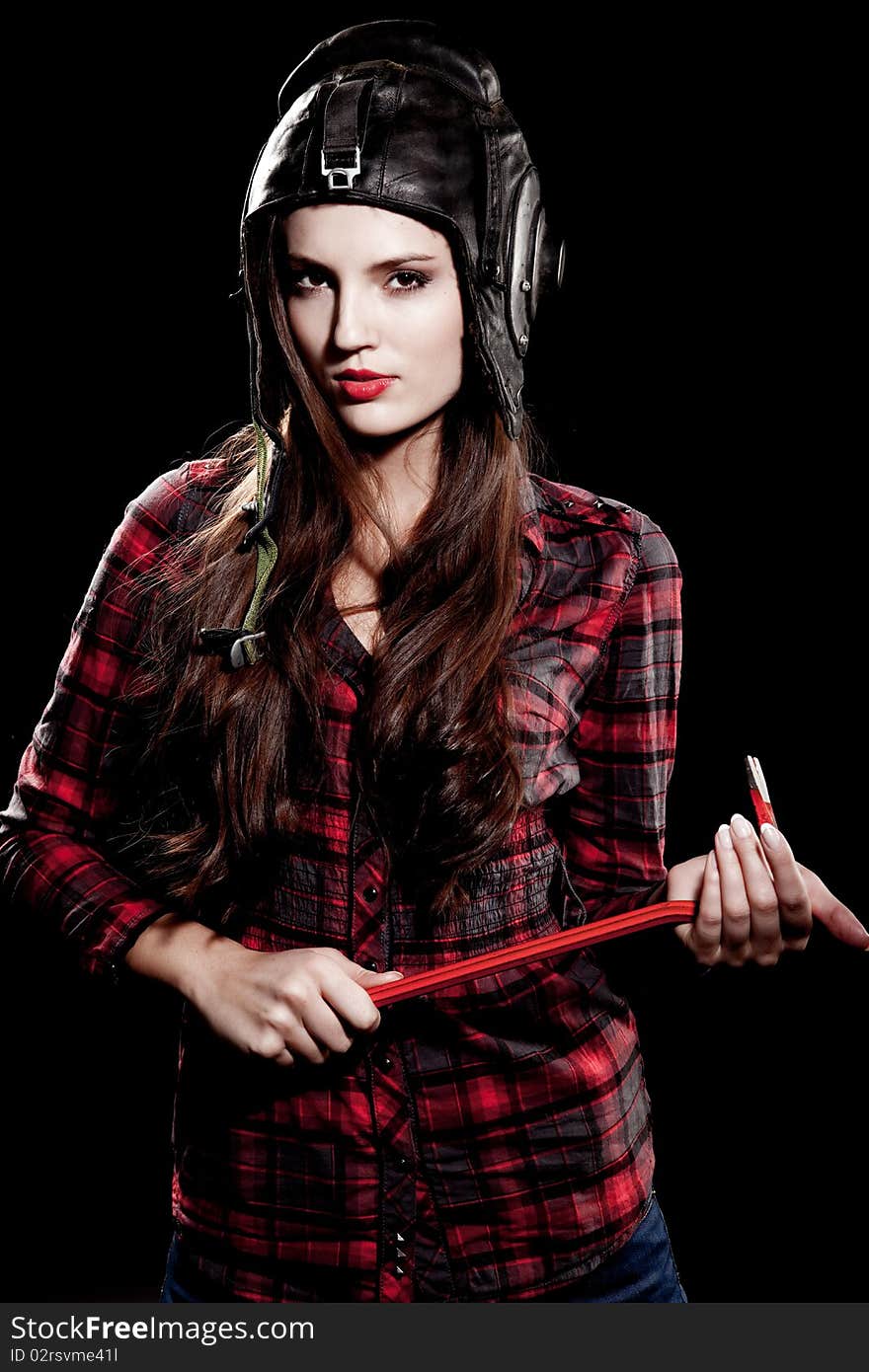 Young beautiful woman in cell shirt with red crowbar. Young beautiful woman in cell shirt with red crowbar