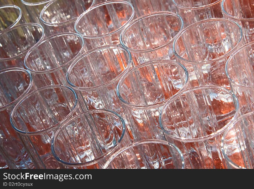 Many empty, transparent glass cup standing on an orange background. View from above. Many empty, transparent glass cup standing on an orange background. View from above.