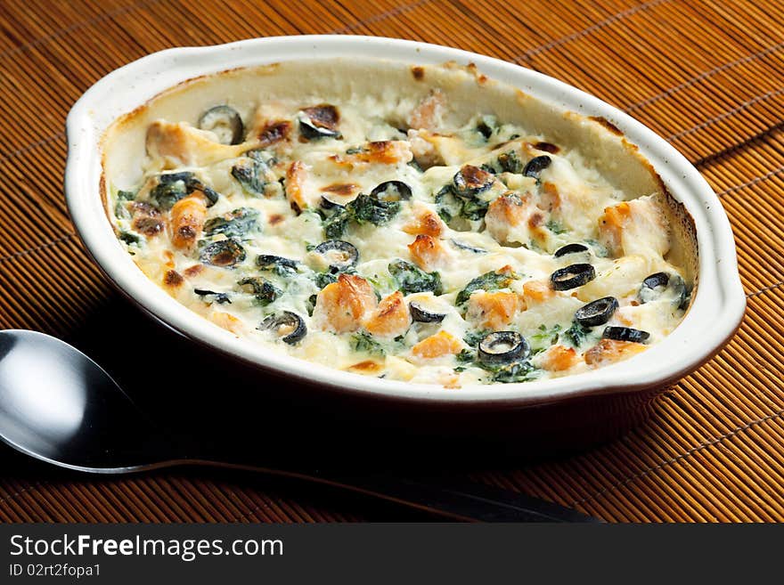 Baked gnocchi with salmon, spinach and black olivves