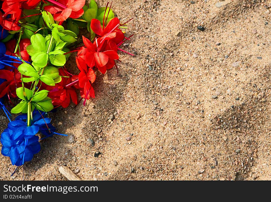 Artificial colorful wreath on the sand.