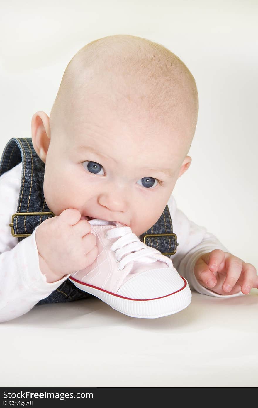 Portrait of lying down baby girl holding a shoe