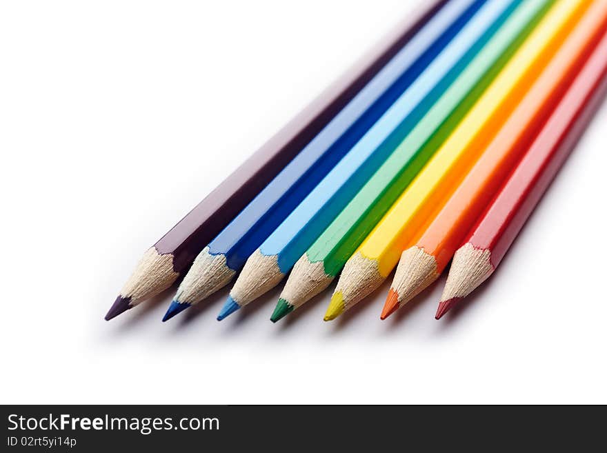 Colored pencils arranged in rainbow spectrum order isolated on white background