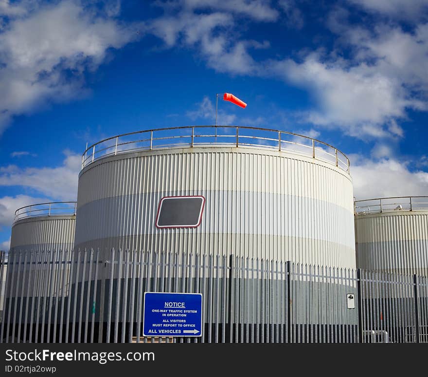 Fuel tanks in industrial area and blue sky with clouds