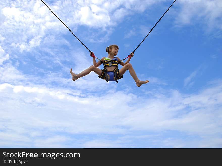 Girl jumping on ropes relating to the blue sky. Girl jumping on ropes relating to the blue sky