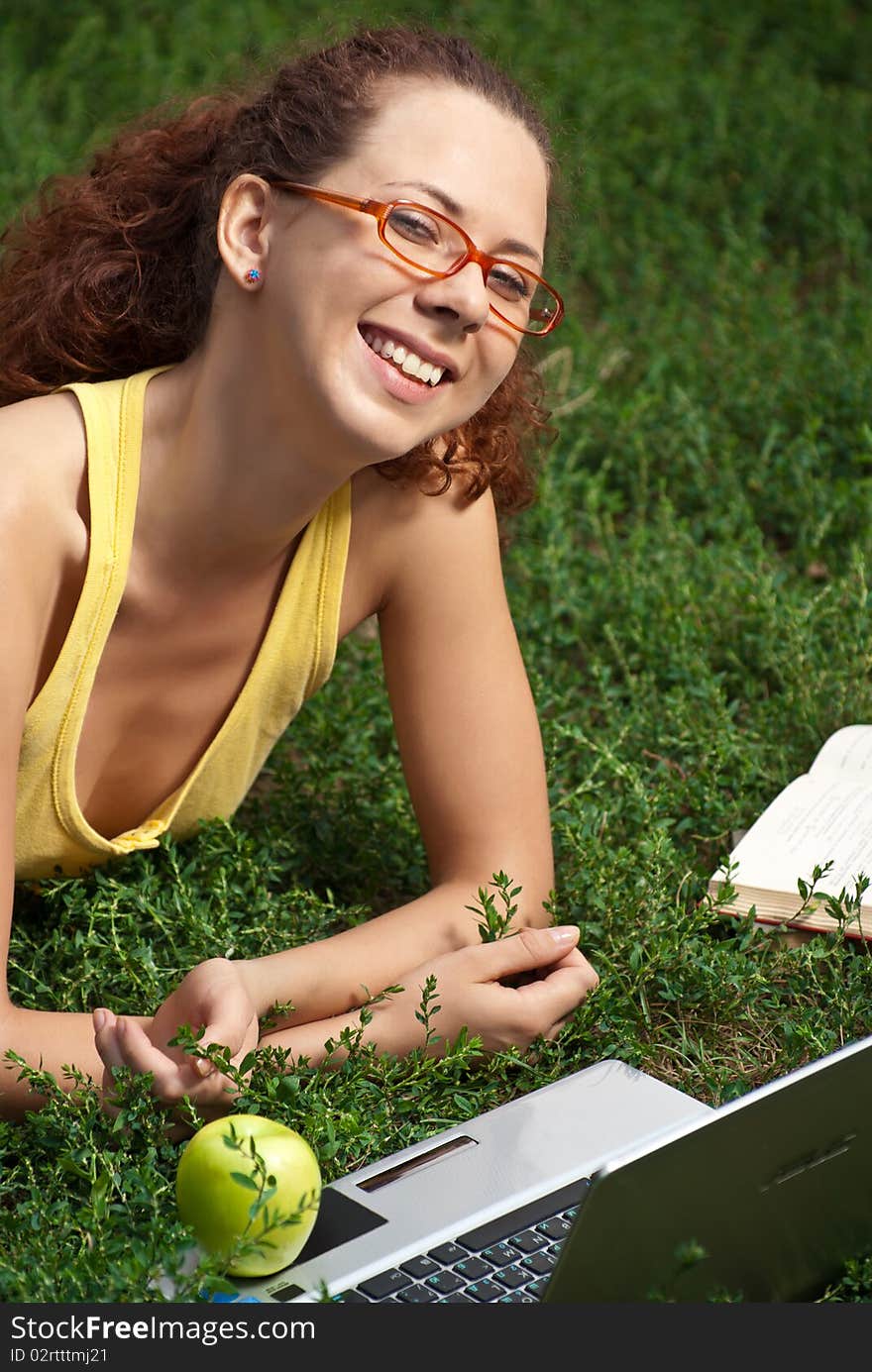 Young Woman with laptop on a meadow