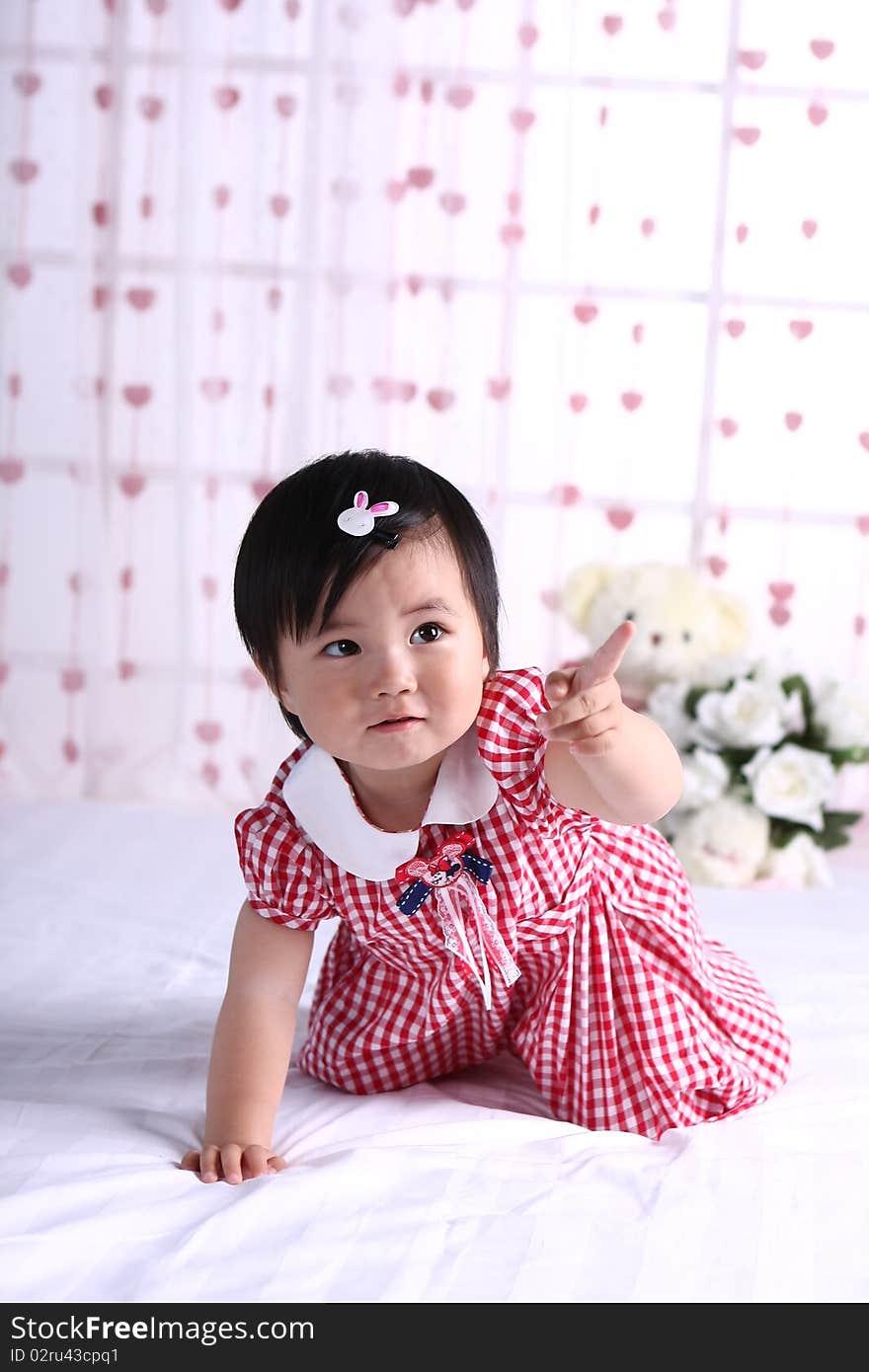 A portrati of a cute baby girl on white bed