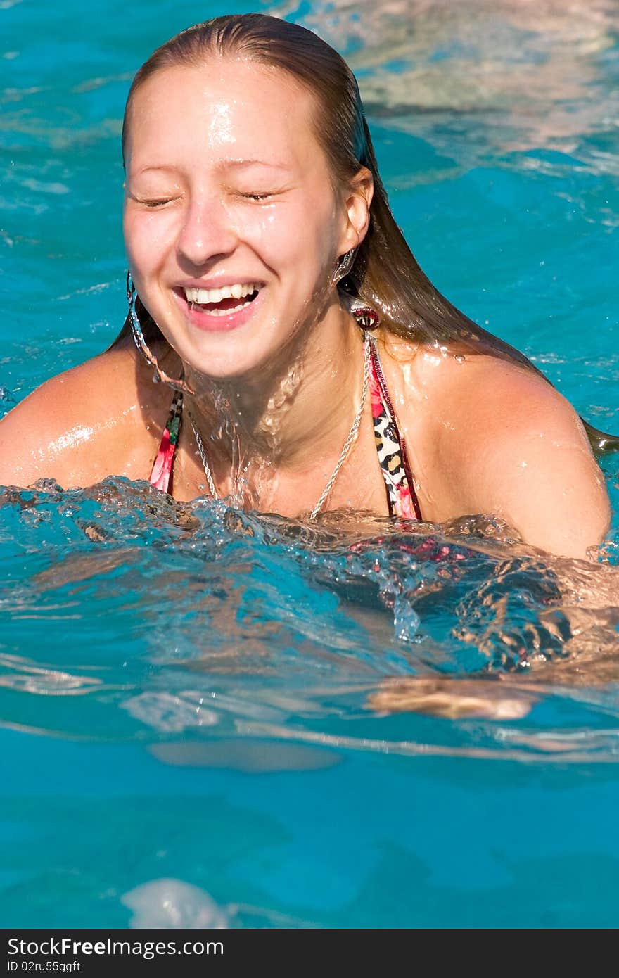 Blond girl swimming in the swimming pool closeup