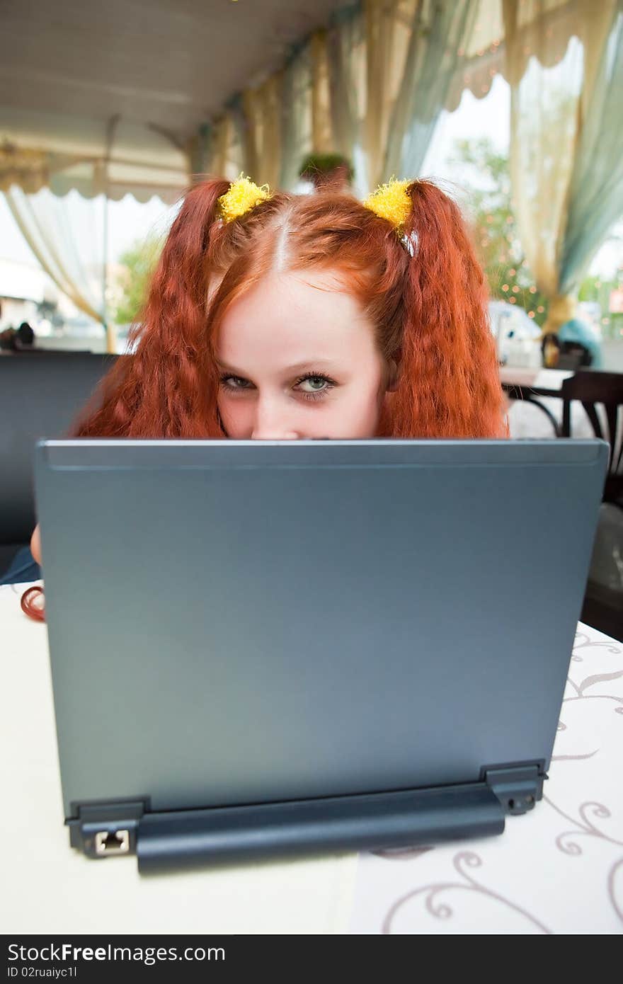 Girl with laptop in cafe. Girl with laptop in cafe