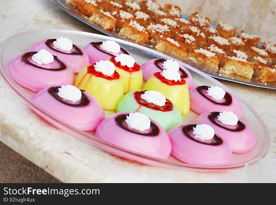 Colored jelly cakes with  chocolate and jam on the tops