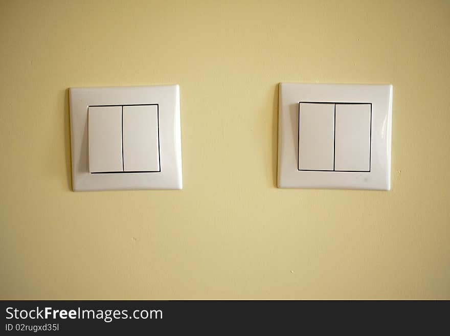 Two light switches on a creme background