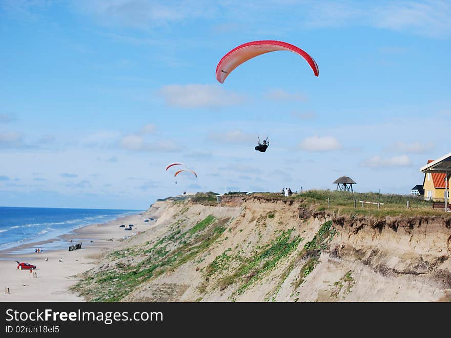 Paragliders flying over the beach on a sunny day