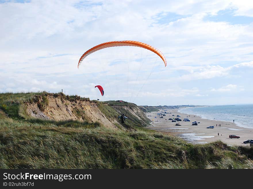 Paragliders flying over the beach on a sunny day