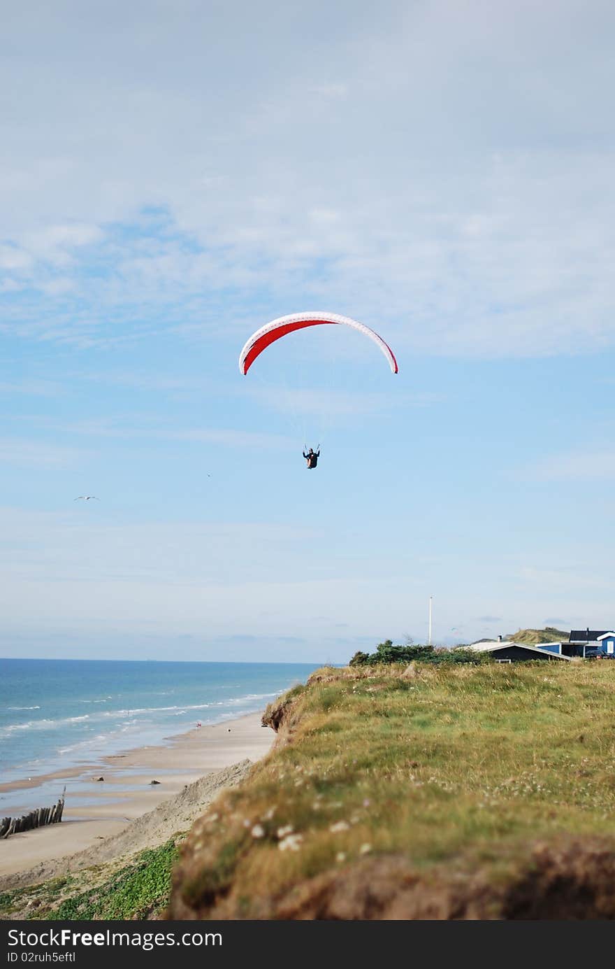 Paragliders flying over the beach on a sunny day