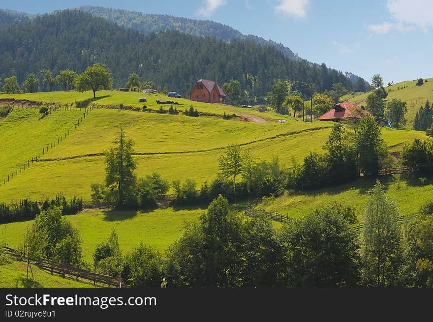 Beautiful country landscape showing mountains, forests, fields and meadows.