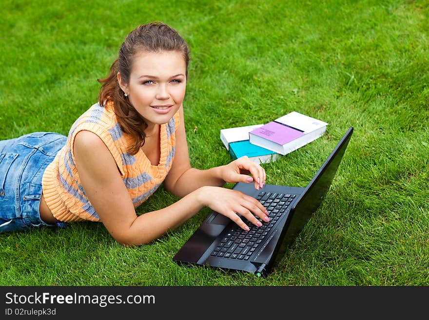 Pretty teenage girl styding on fresh air with laptop and books looking at camera. Pretty teenage girl styding on fresh air with laptop and books looking at camera