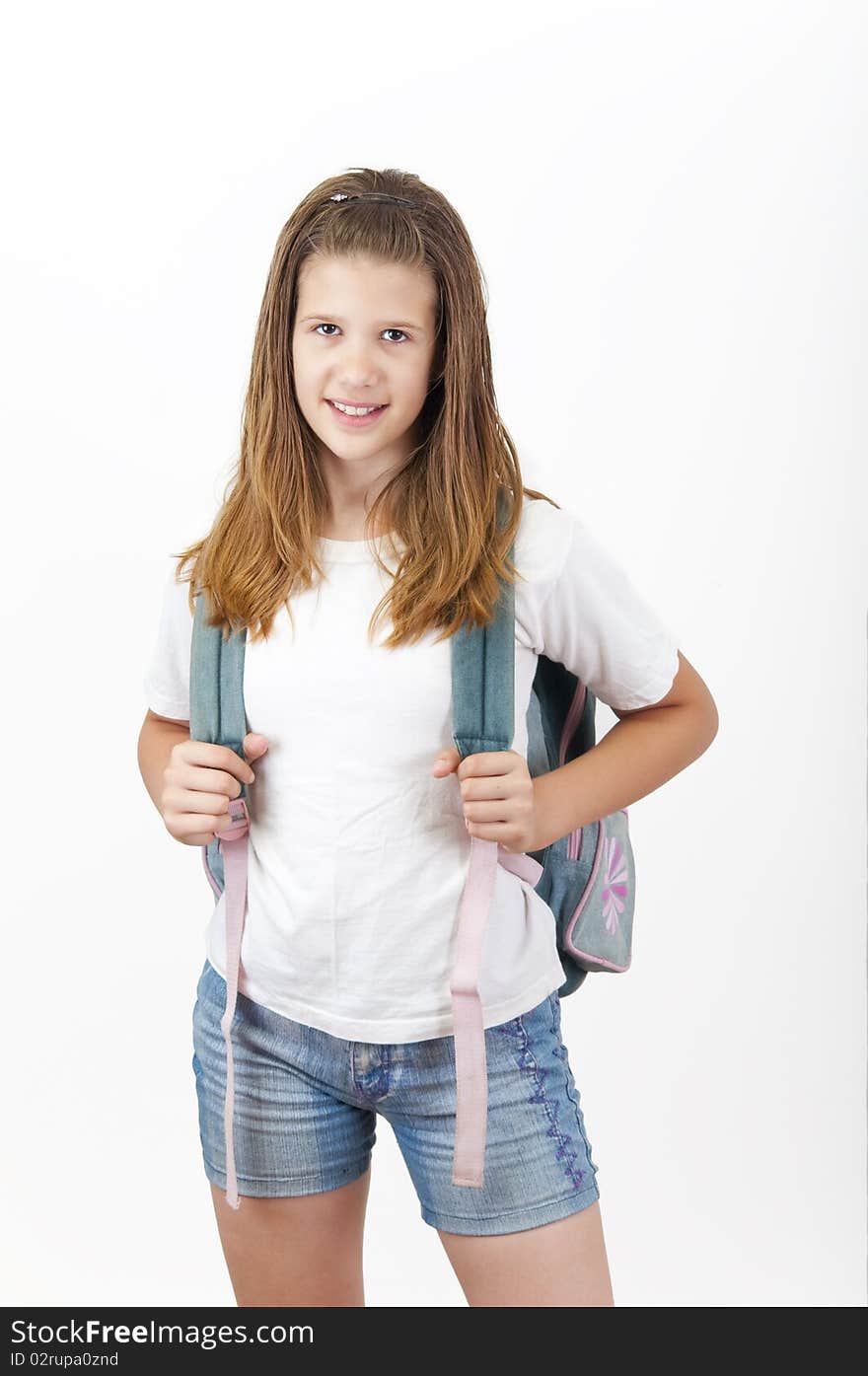 Young smiling girl with school bag on her back.