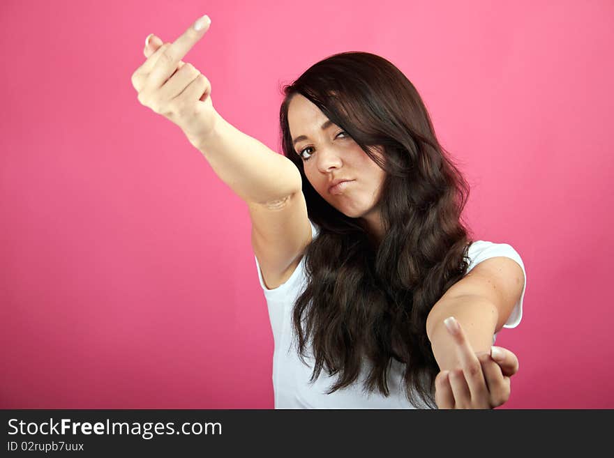 Portrait of a young angry woman is showing her middle-finger. Portrait of a young angry woman is showing her middle-finger