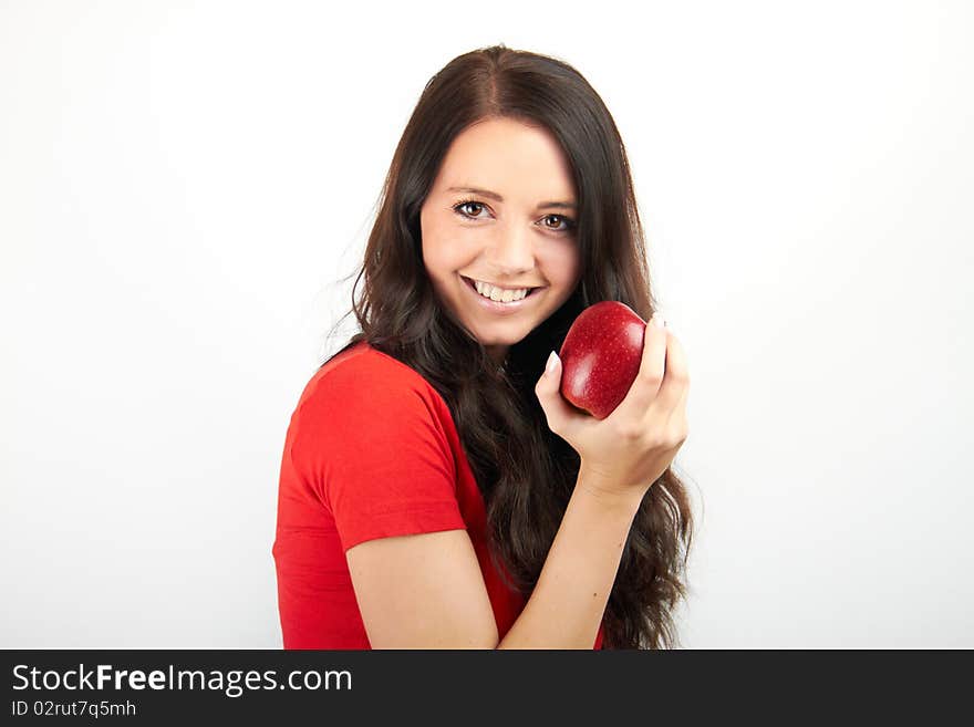 A healthy beautiful happy woman is eating an red apple. A healthy beautiful happy woman is eating an red apple