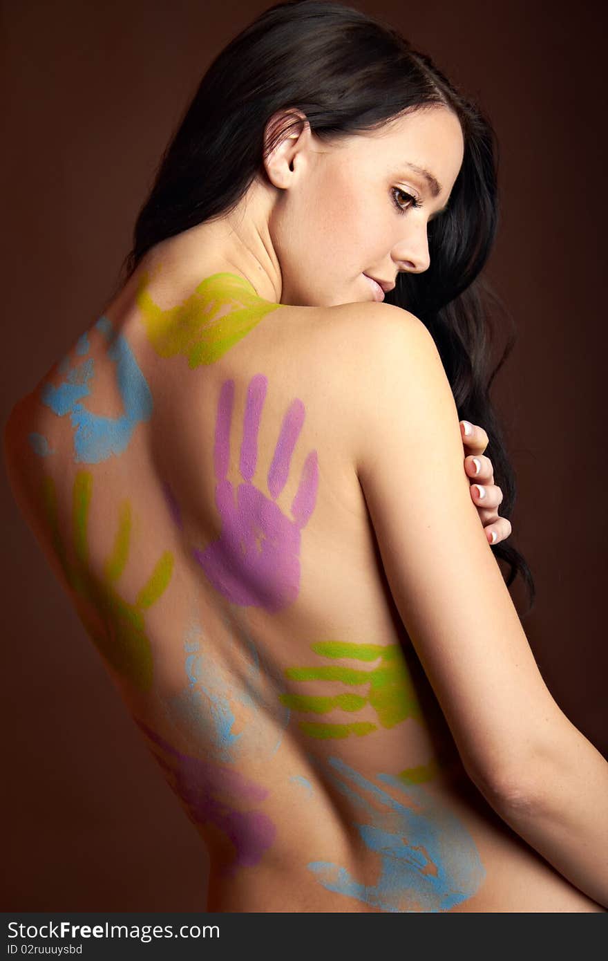 The back of a young woman with bodypainting hands. The back of a young woman with bodypainting hands