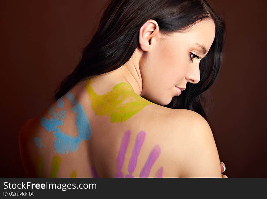 The back of a young woman with bodypainting hands. The back of a young woman with bodypainting hands