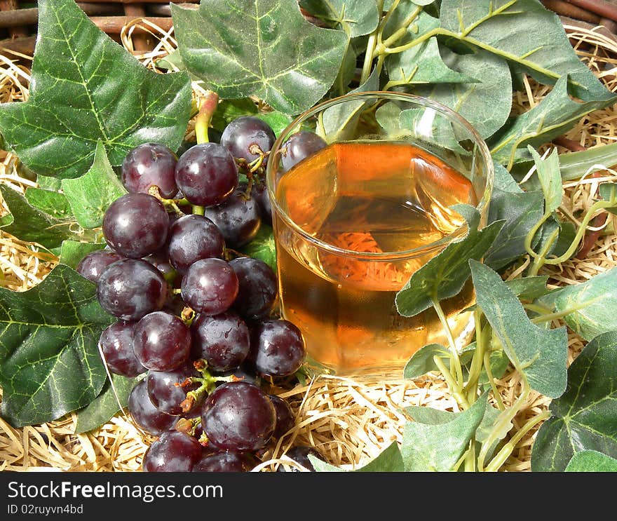 Bunch of grapes and a glass of rose wine. Bunch of grapes and a glass of rose wine