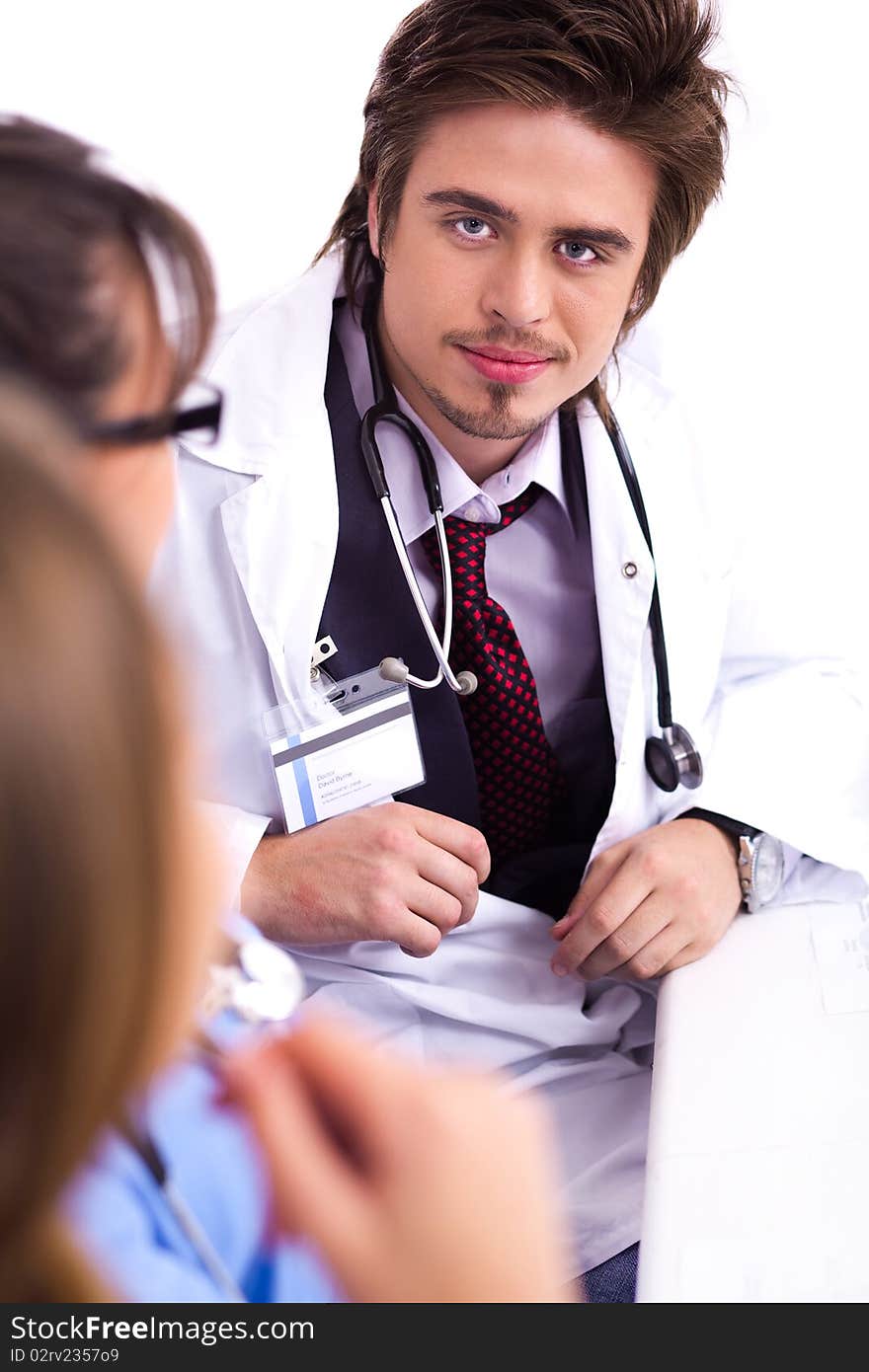 Successful young doctor sitting with hospital stuff and discussing. Successful young doctor sitting with hospital stuff and discussing