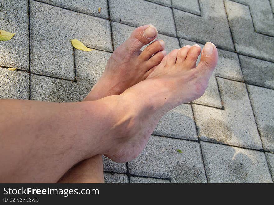 Barefoot on the tiles by the pool. Barefoot on the tiles by the pool