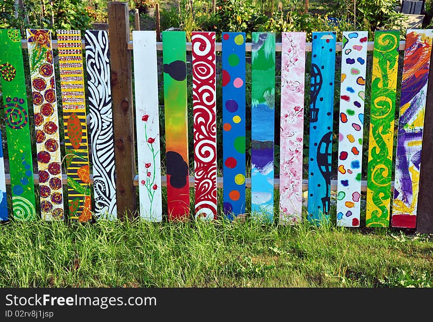 Colorful painted wooden fence in garden. Colorful painted wooden fence in garden