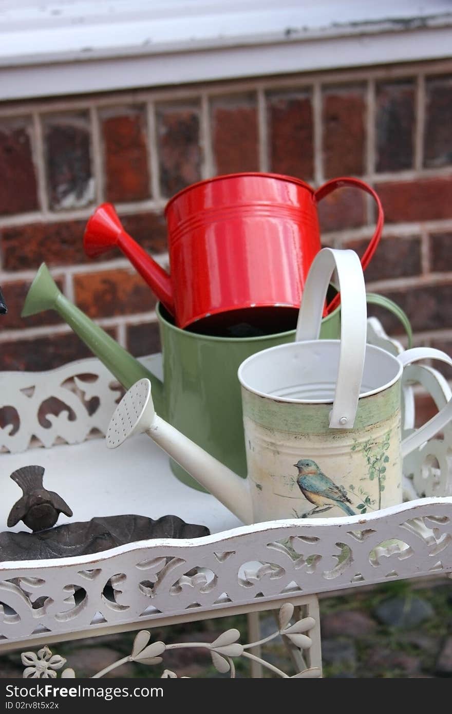 Three watering cans on the shelf