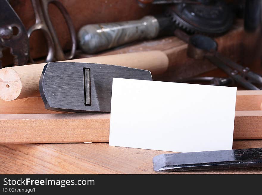 Metalwork workshop with old tools and business card.