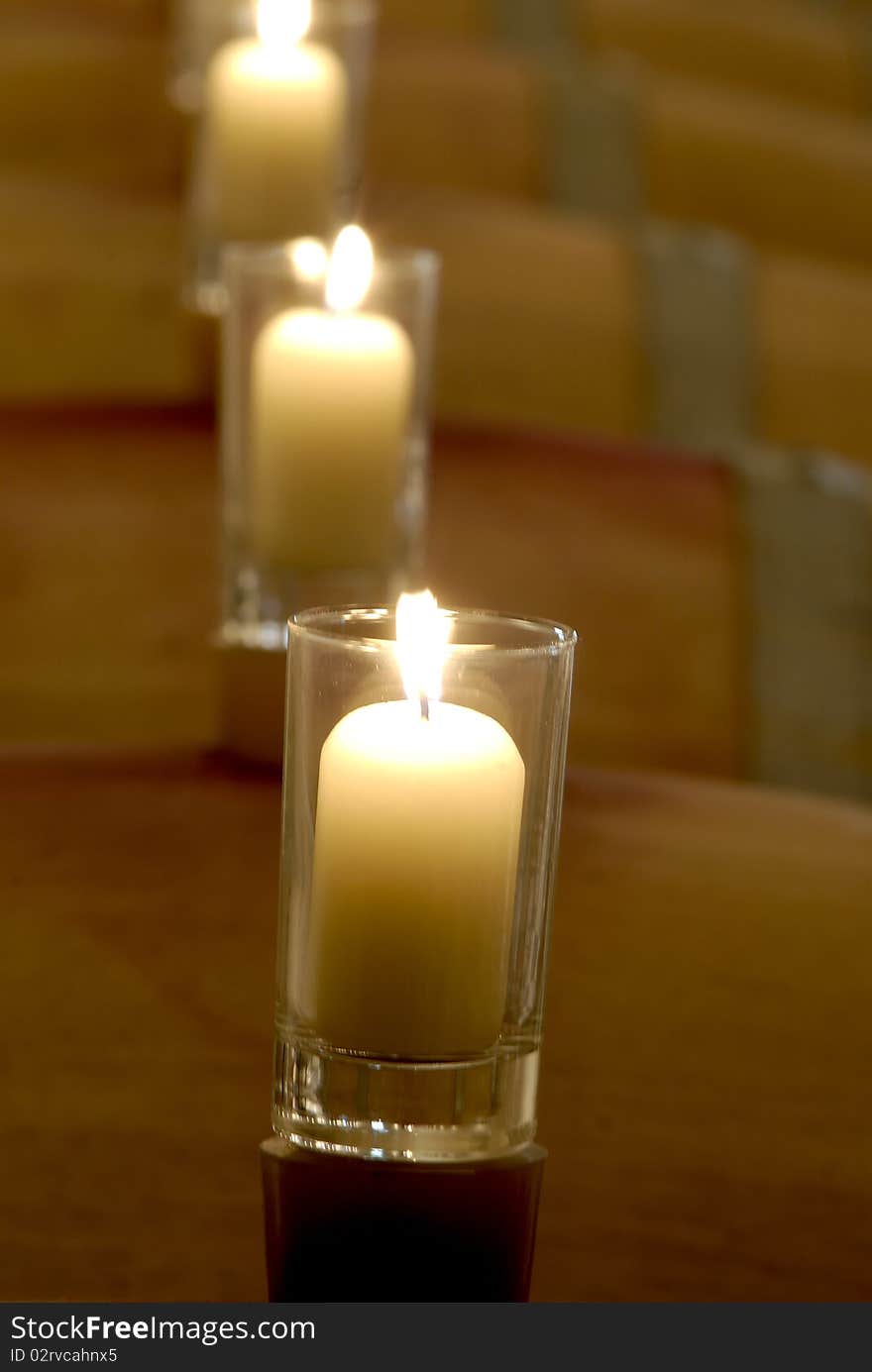 Candles in line standing on top of barrels.