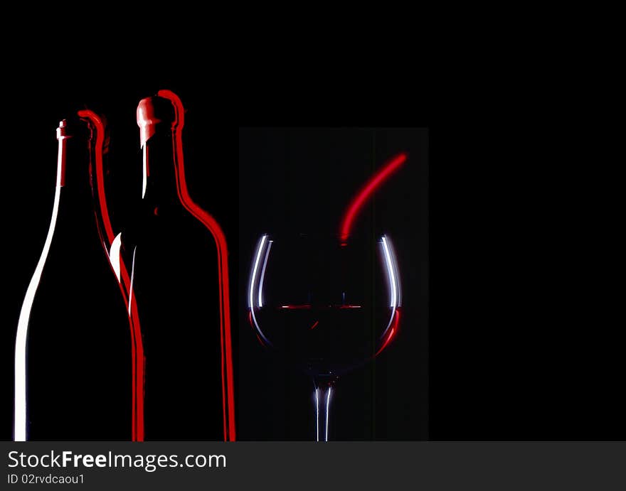 Montage of red wine glass and two bottles with black background